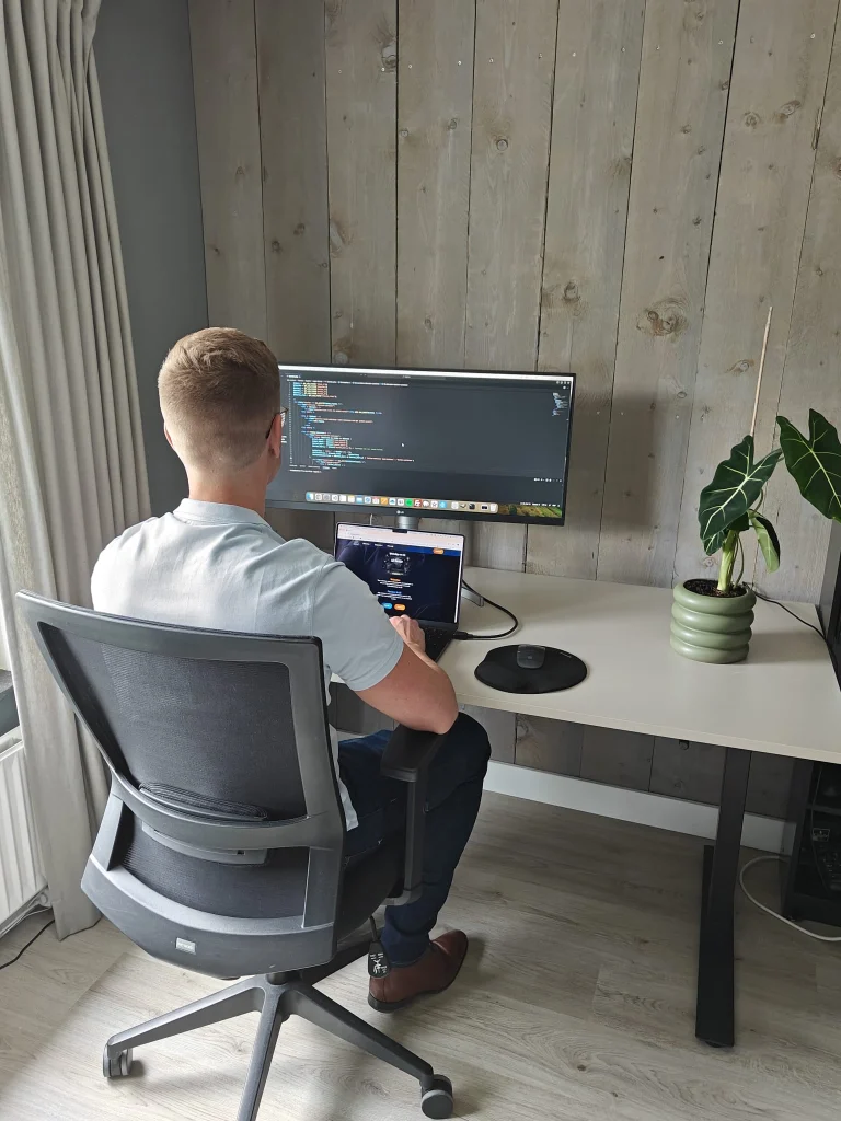 Stijn Metz, Full Stack Developer, aan het werk achter bureau, symboliseert gebruik van AI door Stijn.